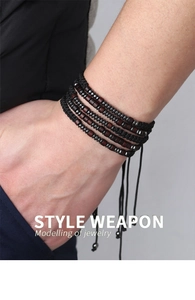 Close-up of men's multi-layer woven bracelet with wooden beads and adjustable cord