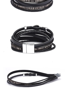 Detail view of multilayer black leather wrap bracelet with silver magnetic clasp and rhinestones