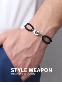 Close-up of men's braided black rope bracelet featuring a silver metal handcuff buckle