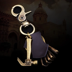 Vintage bronze hammer keychain with pirate skull leather accents on a dark rustic backdrop