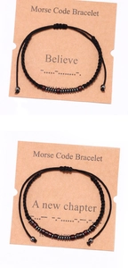 Detail of handcrafted Morse code bracelets with dark wood beads on display cards