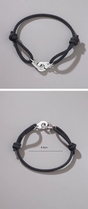 Adjustable black braided rope bracelet with silver metal handcuff charm, width 8.4cm
