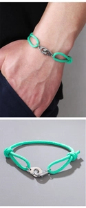 Detail of mint green braided rope bracelet featuring silver handcuff clasp and adjustable knots