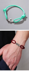 Detail of adjustable woven rope bracelets with stainless steel handcuff clasp in red and green