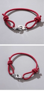 Macro detail of red nautical braided rope bracelet with silver steel handcuff clasp