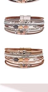Detalle de la pulsera bohemia multicapa de cuero con dijes de hojas y cierre magnético