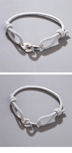 Detailed view of gray braided rope bracelet with silver handcuff clasp and adjustable knots