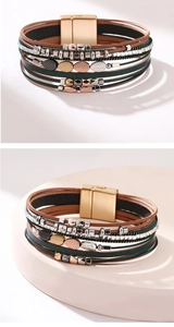Detalle de pulsera bohemia multicapa de cuero con hojas metálicas y cierre magnético