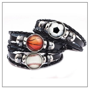 Detailansicht geflochtener Lederarmbänder mit leuchtenden Fußball- und Basketball-Anhängern