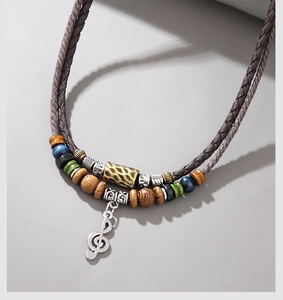 Detail of beaded necklace featuring music note pendant and vintage wooden beads