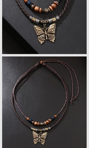 Gros plan du pendentif papillon en bronze avec perles en bois sur cordon tressé ethnique