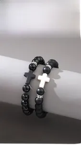 Detail of matte obsidian beads and cross charms on a hand-woven bracelet set