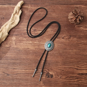 Vintage bolo tie with silver sunflower pendant and turquoise on wood background