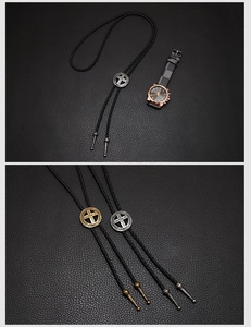 Detail of vintage bolo tie with cross engraved metal slider and braided leather cord