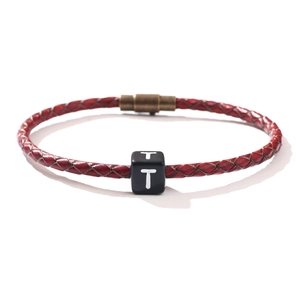 Bracelet tressé en cuir rouge avec perle lettre T noire et fermoir magnétique en bronze