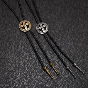 Vintage cross bolo tie with antique gold and silver pendants on black braided cord