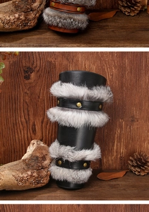 Detail of Viking faux leather bracers with rabbit fur trim and metal rivets on wood