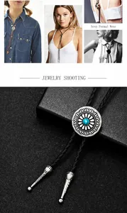 Detail view of vintage silver bolo tie with turquoise stone and woven leather cord