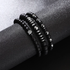 Three-piece set of men's matte black beaded bracelets with metallic disc spacers and charms