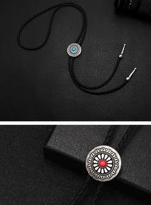 Detail of vintage Western bolo tie with floral metal carving and turquoise stone inlay