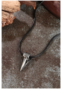Macro shot of Gothic crow skull pendant with vintage metal texture on stone background