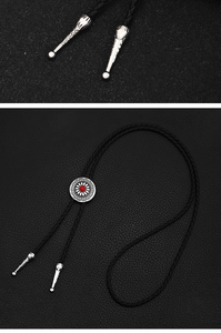 Close-up of vintage bolo tie showing red stone inlay and engraved silver metal tips