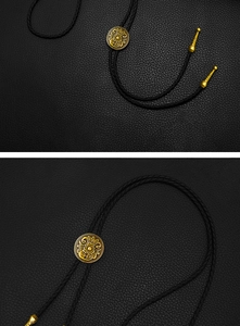 Detail of vintage bronze bolo tie with floral engraving on adjustable slider and leather cord