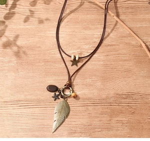 Close-up of bohemian multi-layer necklace with metal leaf, starfish and star charms