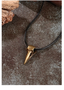 Detail of gothic raven skull pendant with antique bronze finish on black cord necklace
