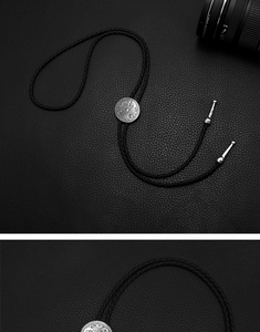 Detailed macro of vintage silver floral engraved bolo tie buckle and woven cord on leather