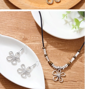 Détail du collier avec pendentif trèfle et boucles d'oreilles sur une assiette en céramique