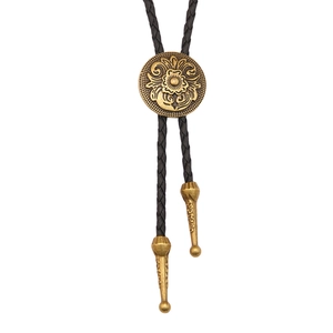 Vintage western bolo tie with golden floral engraved medallion and black woven cord