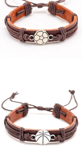 Detalle de pulseras de cuero con dijes metálicos de fútbol y baloncesto