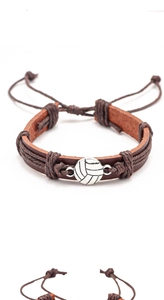 Detalle de pulsera de cuero ajustable con dije de voleibol plateado sobre fondo blanco
