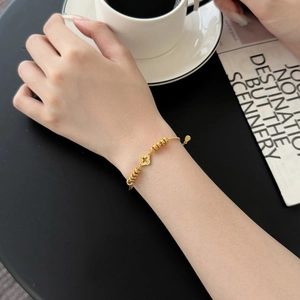 Elegant gold hollow four-leaf clover beaded bracelet with adjustable chain for women