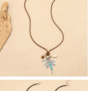 Detail of dragonfly necklace with blue stones, wood beads, and shell on woven cord