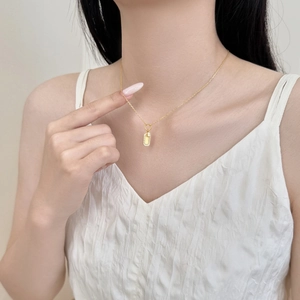 Elegante collana d'oro con pendente rettangolare decorato con zirconi su una catena a croce