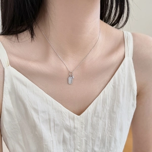 Dettaglio collana S925 argento con pendente rettangolare e micro-pave di cristalli su modella