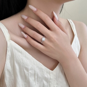 Close-up of a shimmering S925 sterling silver halo ring with a round zircon on a model