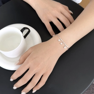 S925 sterling silver clover bracelet with sparkling round charms on a model's wrist
