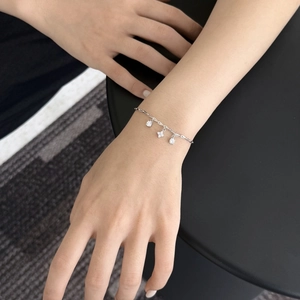 Detail of S925 sterling silver bracelet with four-leaf clover charms on a female wrist