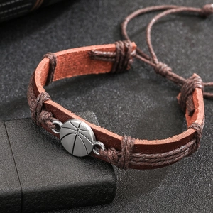 Pulsera retro de cuero marrón con dije de baloncesto de metal plateado y cuerda trenzada