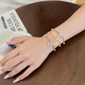 Gros plan de trois bracelets tressés en argent S925 avec breloque cœur au poignet