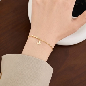 Elegant gold butterfly charm bracelet with faceted beads on a silver-gold mixed chain