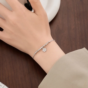 Elegant S925 sterling silver bracelet with floral pendant on a female wrist
