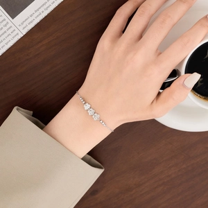 Elegant S925 sterling silver bracelet with floral charms and beads on female wrist