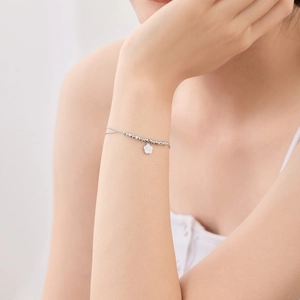 Detailed view of an S925 sterling silver bracelet featuring a delicate white flower pendant