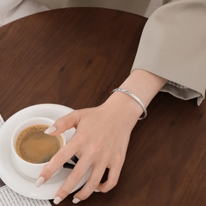 Detail of S925 sterling silver frosted bracelet worn with a stylish coffee-themed background