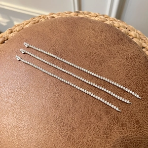 Detailed view of three stacked S925 sterling silver tennis bracelets with round zircons