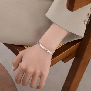 Close-up of S925 sterling silver cuff bracelet with delicate textured wave patterns